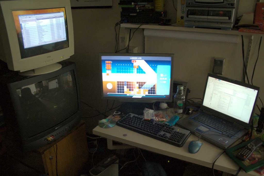 A CRT monitor, a LCD monitor, and a laptop with its screens turned on.